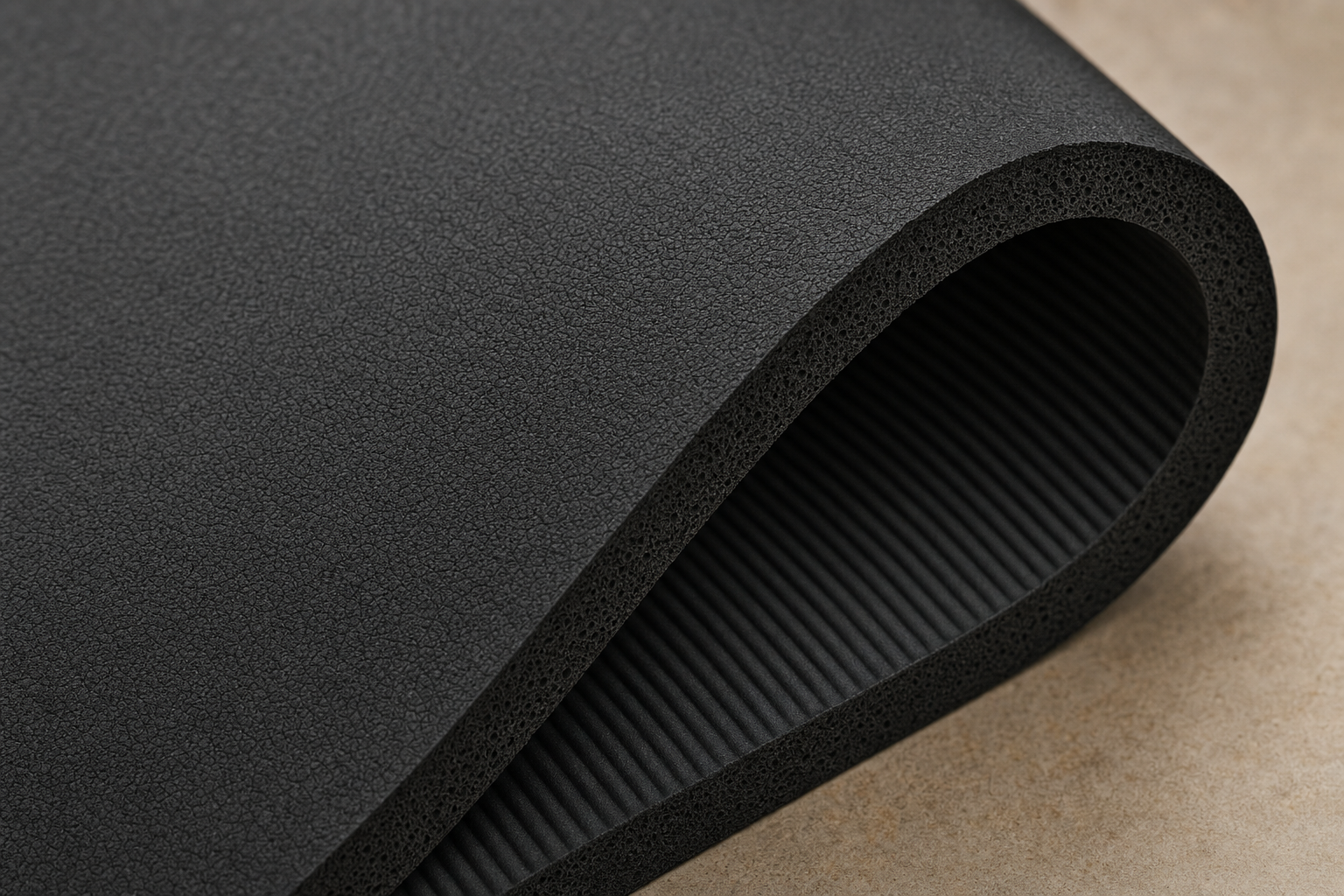 Close-up of black closed-cell foam yoga mat surface texture and underside corner