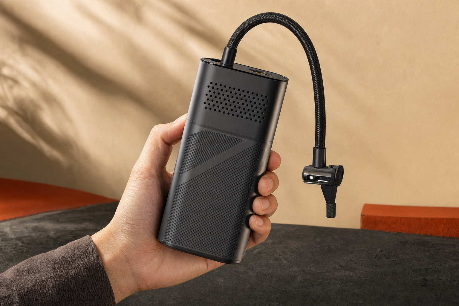 AstroAI AIRUN L7 cordless tire inflator held in one hand showing its compact portable size