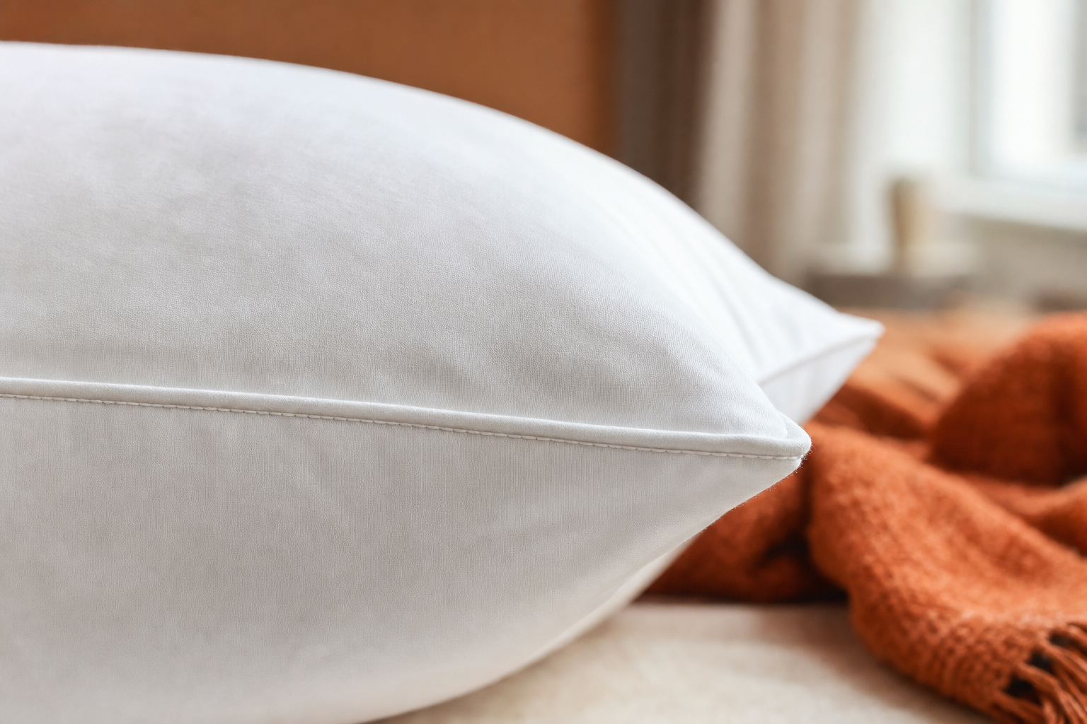 Close-up of white bed pillow fabric texture and edge stitching detail