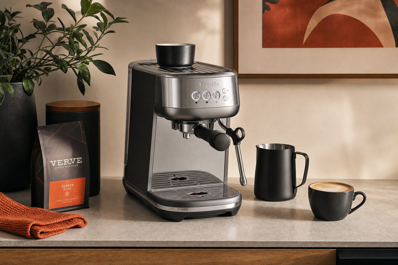 Breville Bambino BES450BSS beside milk pitcher and cup on kitchen counter.