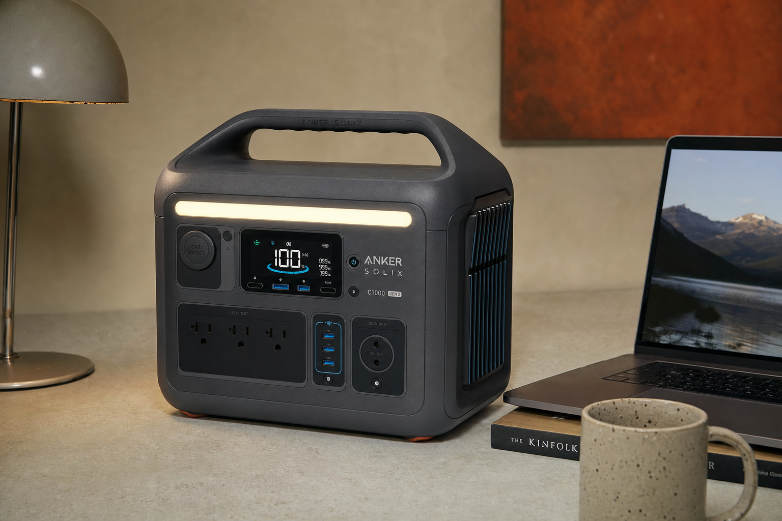 Anker SOLIX C1000 Gen 2 portable power station beside a laptop and small lamp for size context