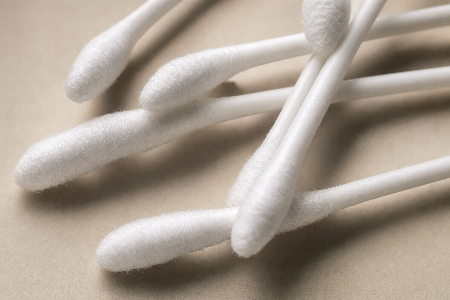 Close-up of white double-tipped cotton swab tips showing cotton texture and density