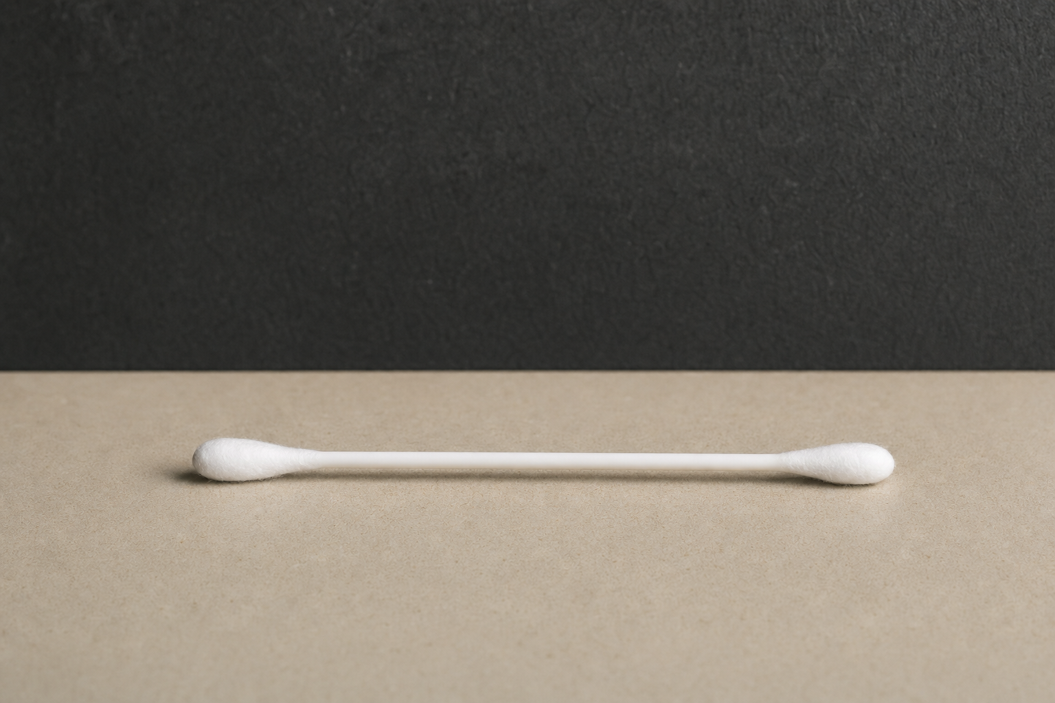 Single white double-tipped cotton swab showing full stem and both cotton tips